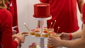 Torta aziendale rossa con logo e cupcake fiera di Bologna - Piece of Cake Italia