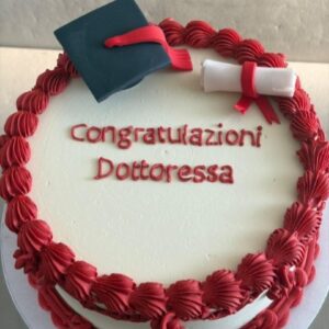 Torta di laurea personalizzata a Bologna con scritta Congratulazioni Dottoressa, tocco accademico e pergamena, decorata con ciuffi di crema al burro meringata rossa